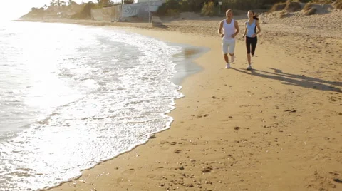 Young couple running on the beach Stock Footage 43677485
