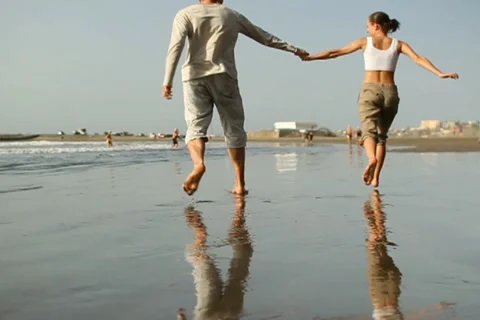 Young couple running on the beach, slow motion NTSC Stock Footage 10894414