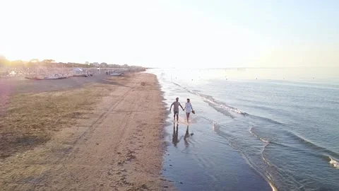 Young couple running on the beach at sunset Stock Footage 137440527
