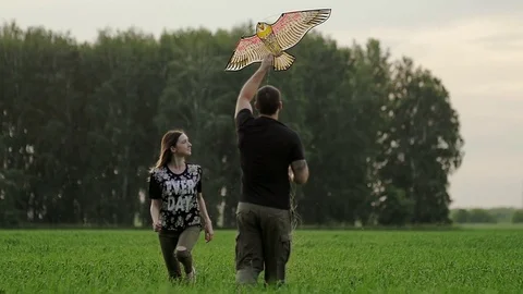 Young couple is running behind a kite Video stock 79610337