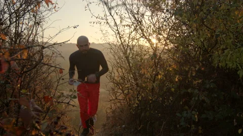 Young couple running between bushes towards the camera holding maps in their Stock Footage 166157275