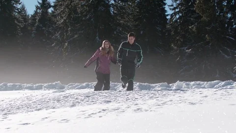 Young couple running in high snow and falling over on a sunny day Vídeo Stock 85076859