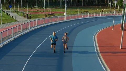 Young couple running on a track Stock Footage 100031091