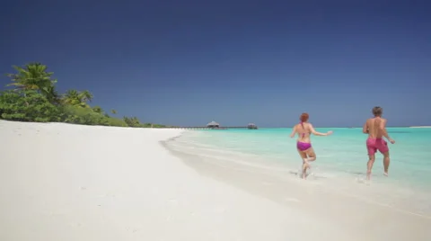 Young couple running into waves Stock Footage 1009075