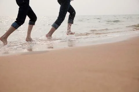 Young Couple Running in the Waves Stock Photos