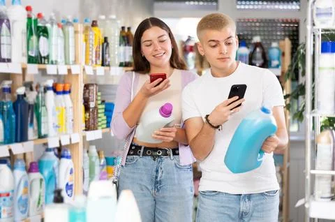 Young couple scanning QR-code on detergent in department store Foto stock