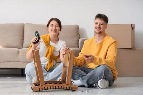 Young couple with screwdrivers assembling table at home Stock Photos