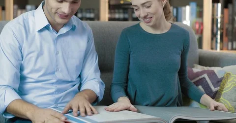 Young couple select wallpaper on samples from the catalog Stock Footage 82969702