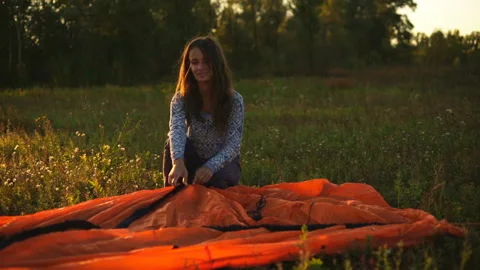 A young couple sets up a tent in a mountain forest at sunset. Stock Footage 116550645