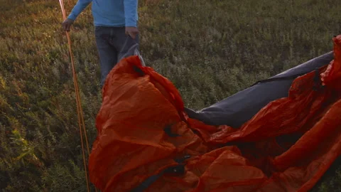 Young couple sets up a tent in a mountain forest at sunset. Stock Footage 116955938