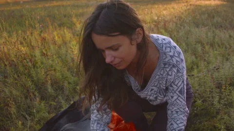 Young couple sets up a tent in a mountain forest at sunset. Video stock 116956124