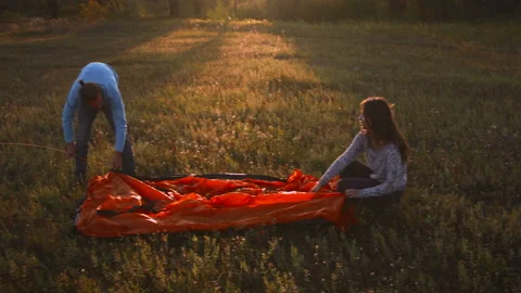 Young couple sets up a tent in a mountain forest at sunset. Stock-Footage 116956631