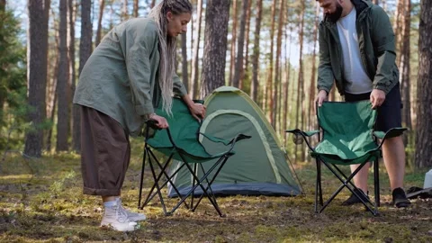 Young couple setting up campsite in pine forest Stock Footage 327527969