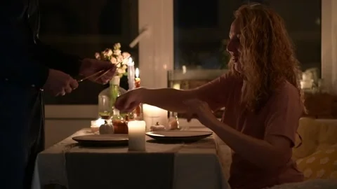 Young couple setting cutlery on the table while preparing for a dinner 库存影片 330804510