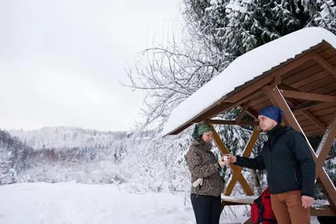 Young couple sharing coffee while out for a winter hike Stock Photos