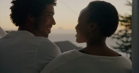 Young couple sharing a kiss while watching the view from their door. 스톡 동영상 88374153