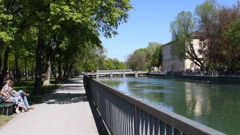 A young couple sits and talks on a bench on the embankment of the Isar River Stock Footage 121166473