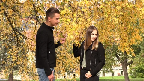 A young couple sits on a white bedspread in autumn park Vidéo 96518019