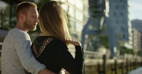 Young couple sitting and looking at the water in beautiful backlit in Hafenci Stock Footage 78984656
