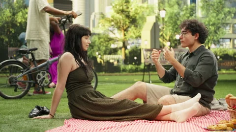 Young couple sitting and talking on romantic picnic date together Stock Footage 341409907