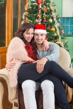 Young Couple Sitting in Armchair in Home in Festive New Year's Stock Photos