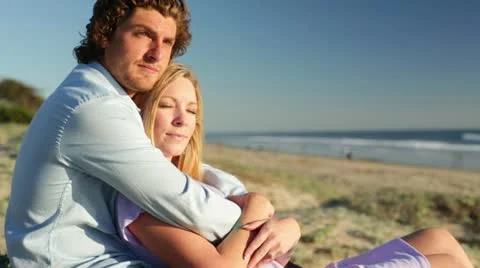 Young Couple Sitting on Beach Stock Footage 21834431