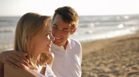 Young couple sitting on beach Stock Footage 43619249