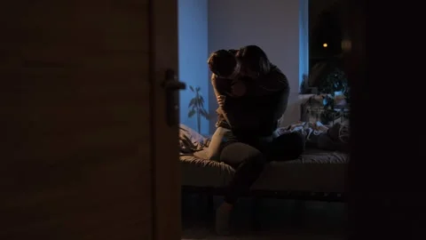 A young couple sitting on a bed under soft evening lighting, romantically embrac Stock Footage 296239219