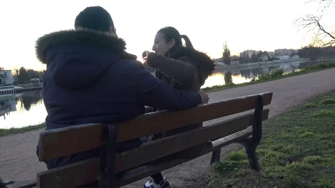 Young Couple Sitting on a Bench Stock Footage 123053257