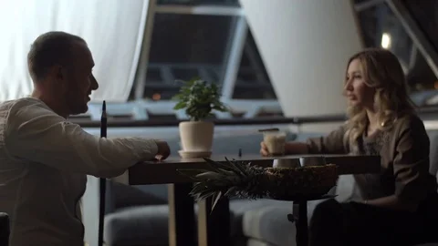 Young couple is sitting in cafe, communicating, smoking hookah.  Stock Footage 83667466
