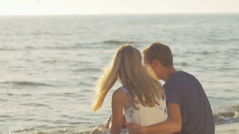 Young couple sitting close to each other on the sand Stock Footage 73780197