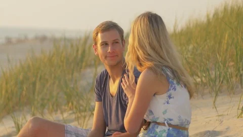 Young couple sitting close to each other on the sand Video stock 73782268