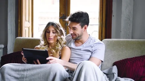 Young couple sitting on coch with tablet. Stock Footage 74727943