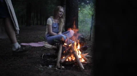Young couple sitting in a forest fire. Man closes Woman in plaid and kisses. Stock Footage 68396024