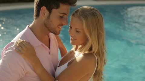 Young couple sitting by pool Stock Footage 43625401