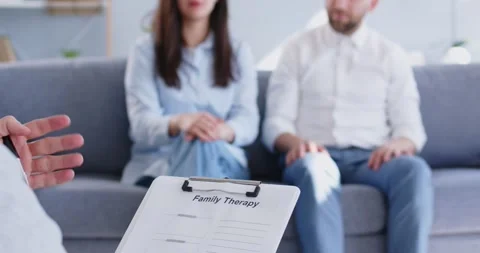 Young couple sitting on sofa and talking with psychologist on therapy session. Stock Footage 269205867