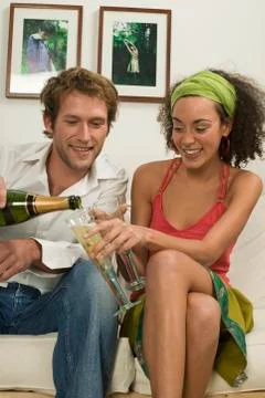 Young couple sitting on sofa Stock Photos