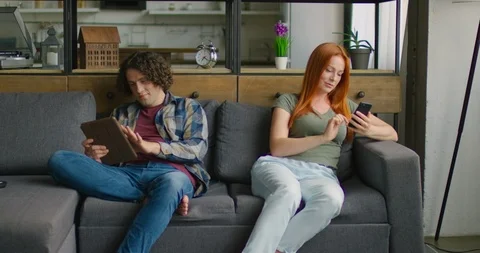 Young Couple Is Sitting on Sofa, Spending Time in Social Media Stock Footage 115935614