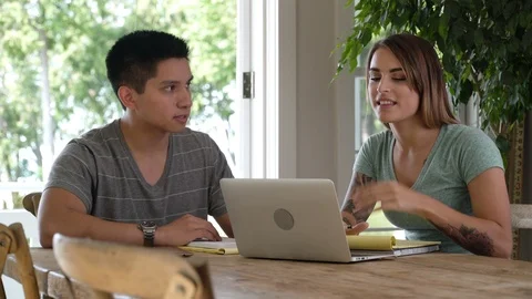 Young couple sitting at table with laptop. 動画素材 88041498