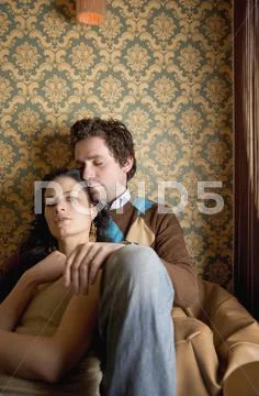 Young couple sitting together on a bean bag Stock Photos