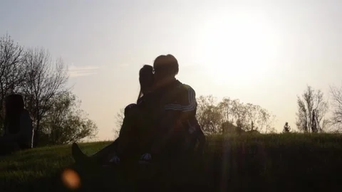Young Couple Sitting on The Top of a Hill While Cuddling Stock Footage