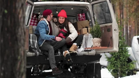 A Young couple is sitting in a trunk of retro car with holiday's brights in Stock Footage 259303173