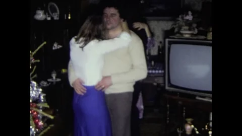 Young couple slow dancing during a christmas family party in the 1980s Stock Footage 326312803