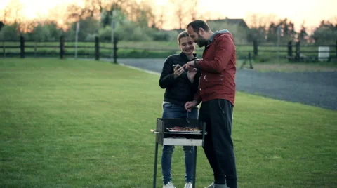Young couple with smartphone talking and grilling in the country HD Stock-Footage 49973876