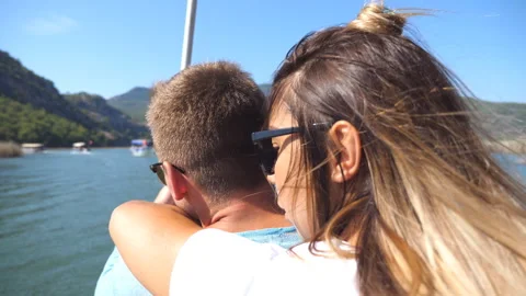 Young couple spending time together on deck of sailboat at sunny day. Hugging Stock Footage 305749407