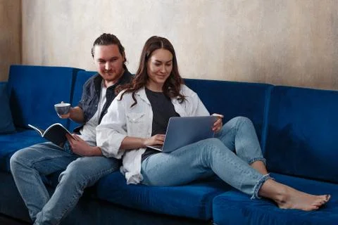 A young couple spends time at home, studying and playing or working, reading, Фото