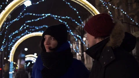 Young couple spends time together on busy urban street in evening taking photo Stock Footage 83922681
