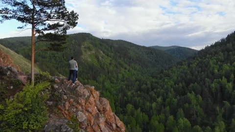 A young couple stand on the edge of a cliff and enjoy the beautiful view. Stock Footage 111119301