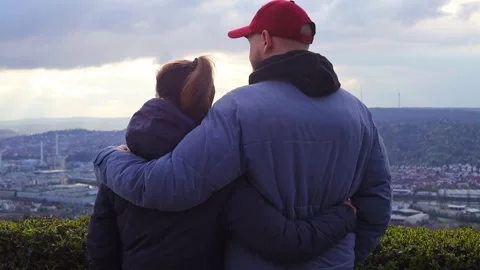 A young couple stand embracing looking at the panorama of the city Stock Footage 251475758
