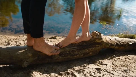 Young couple stand on the log and kiss each other Stock Footage 74076986